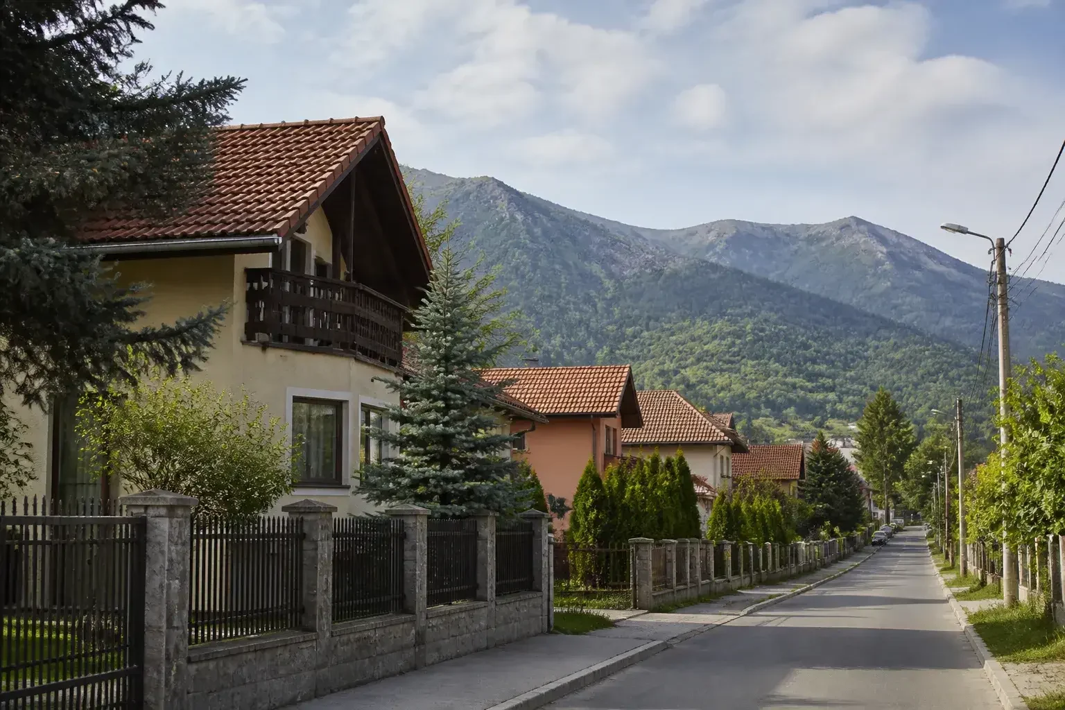 Cartier liniștit din Săcele, cu case și dealuri împădurite.